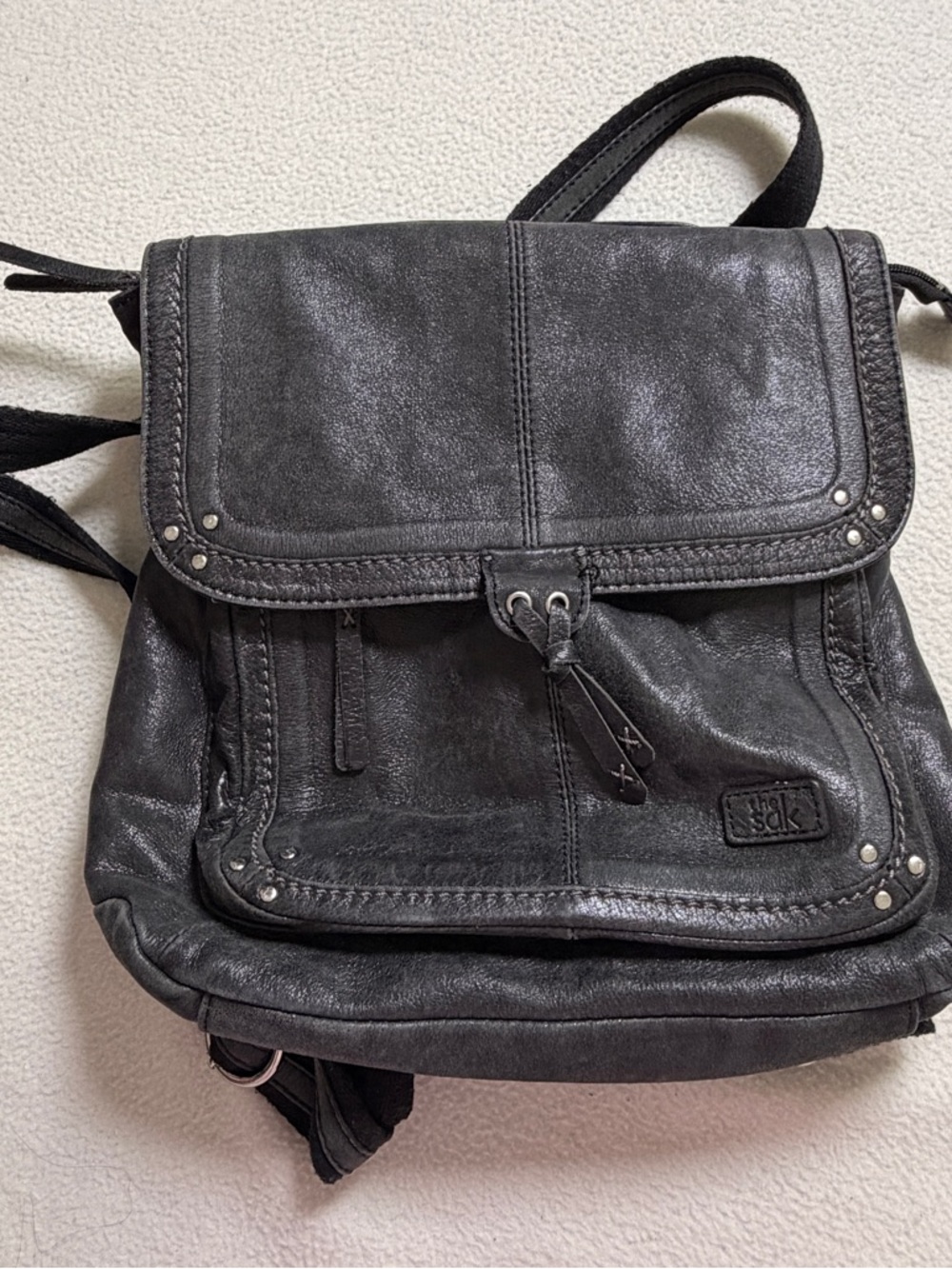The Sak Black Leather Flap Backpack with Stud Accents